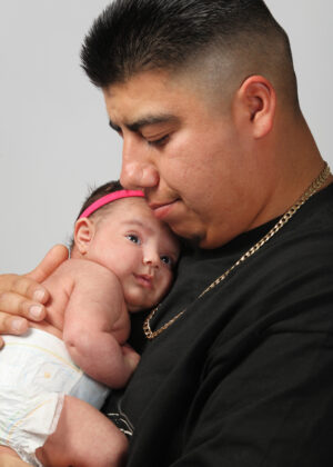 man holding newborn baby daughter
