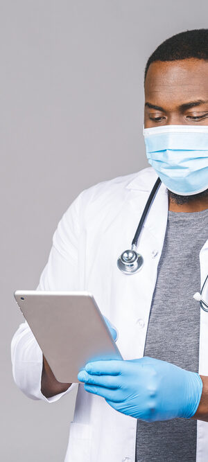 medical person with face covering and tablet