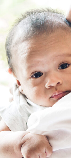 mom holding and kissing newborn baby
