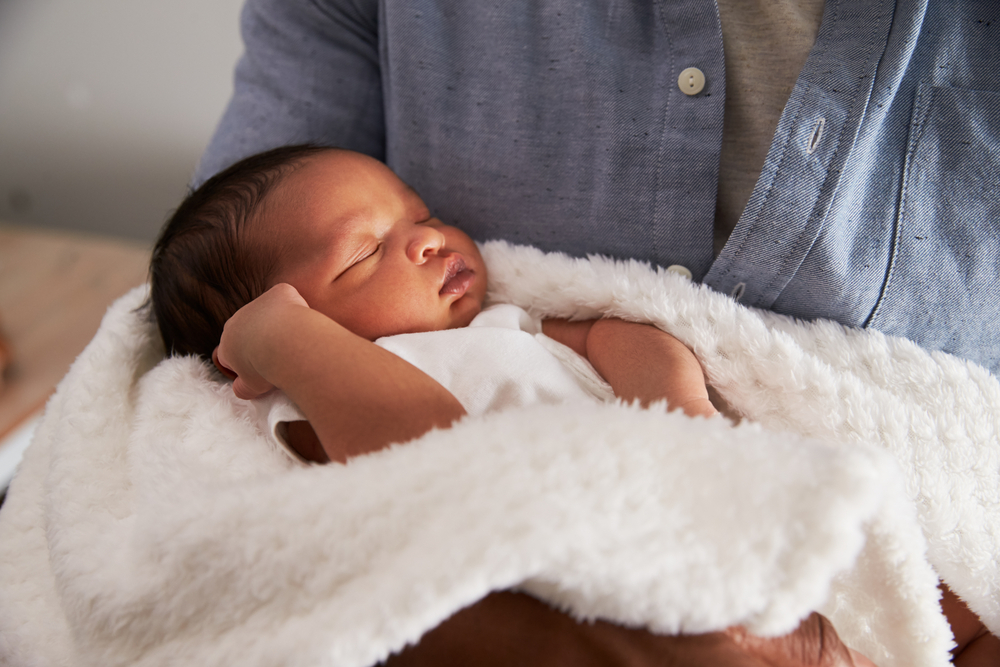 newborn-baby-being-held-in-arms-wyoming-department-of-health