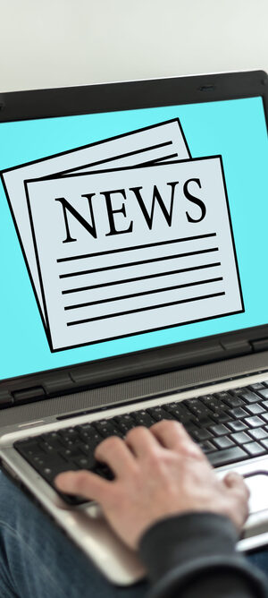 news on laptop on lap