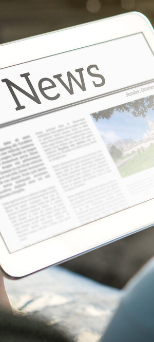 news on tablet with hands