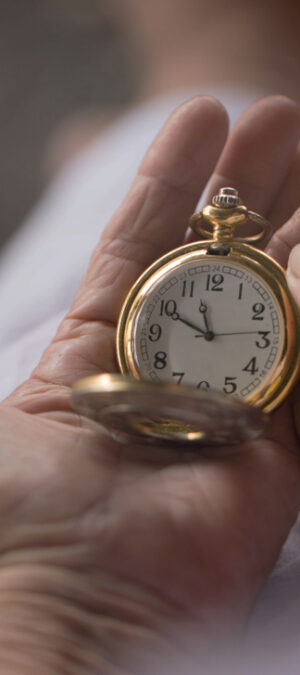 old hands holding pocket watch