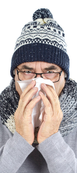 older man blowing nose