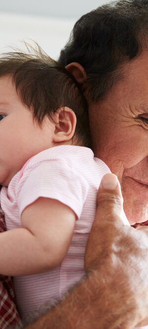 older man holding baby girl