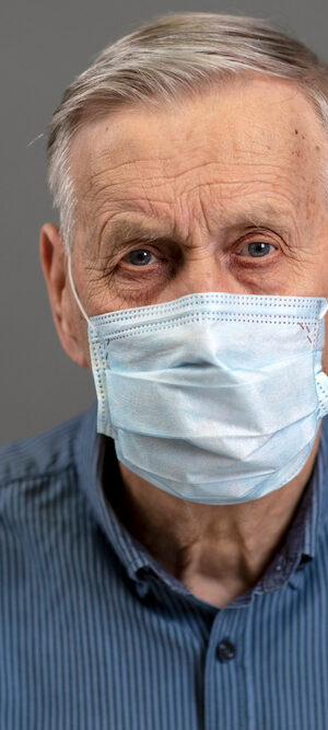 older man with face covering and blue eyes