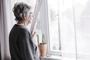 older woman looking from window