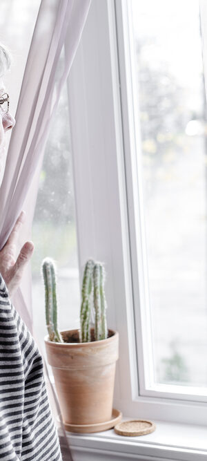 older woman looking from window