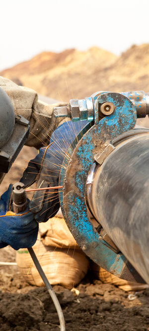 person welding on pipe