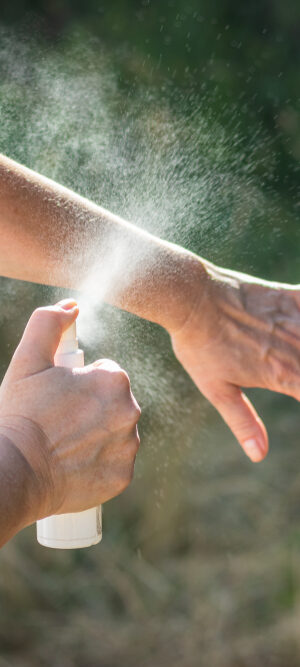 putting bug spray on arms