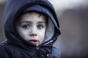 sad little boy with coat
