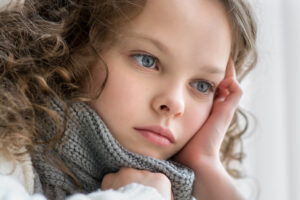 sad little girl with grey scarf