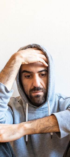 sad man sitting in hoodie