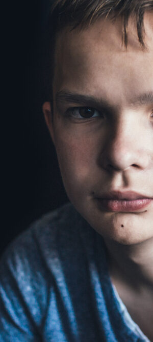 sad teen boy in blue shirt