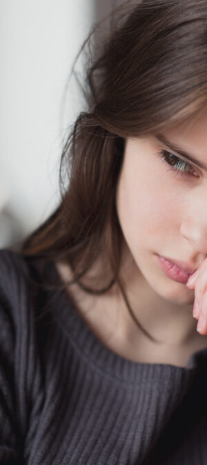 sad teen girl in grey sweater