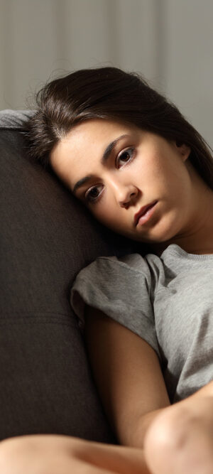 sad teen girl sitting on couch