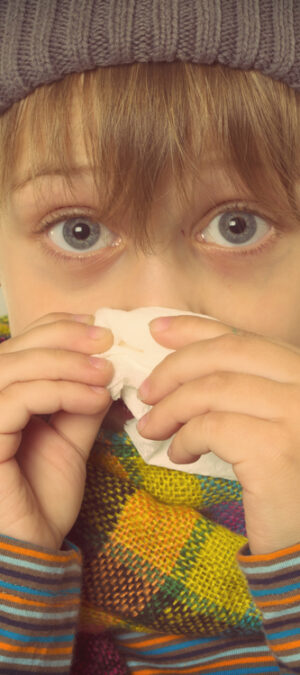 sick boy with tissue and scarf