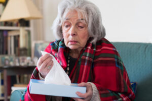 sick older woman with tissues