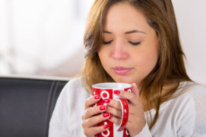sick woman with hot drink mug