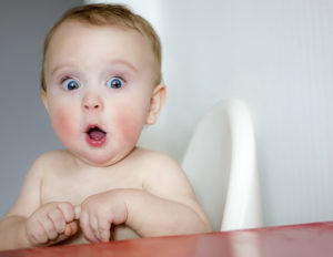 surprised baby with red cheeks