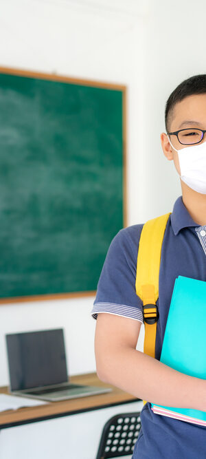 teen boy in class with face covering