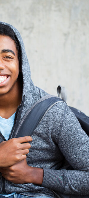 teen with grey hoodie and backpack