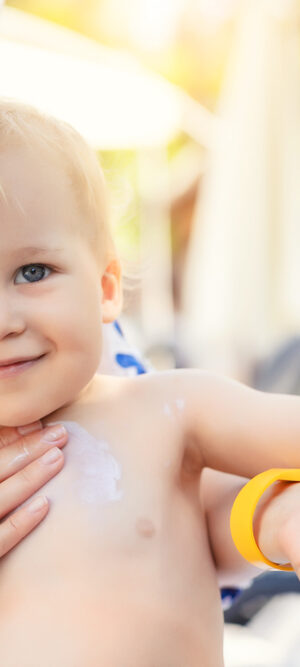 toddler getting sunscreen outdoors