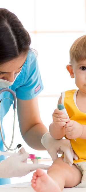 toddler in yellow getting vaccine