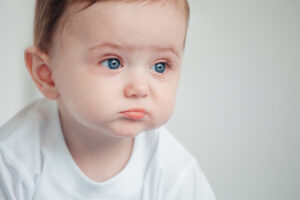 unhappy baby in white tshirt