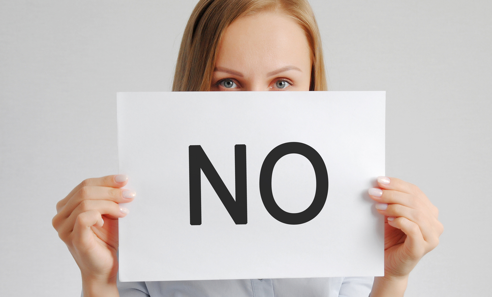 woman holding no sign - Wyoming Department of Health