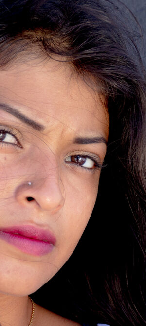 woman in front of dark brick wall