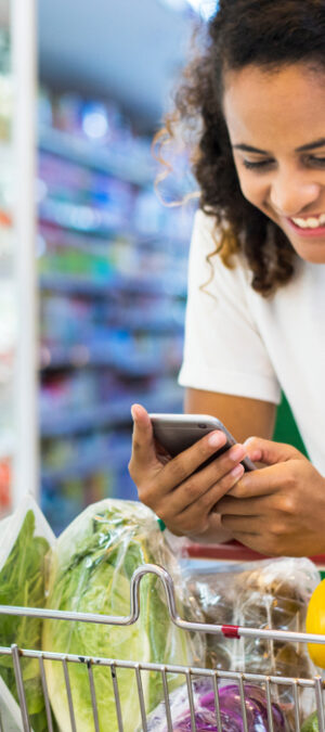 woman looking at phone in grocery store