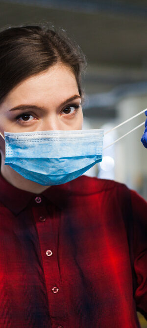 woman putting on face covering