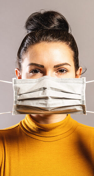 woman with yellow shirt and face covering