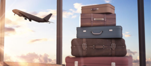 A stack of suitcases with airplane taking off in the background
