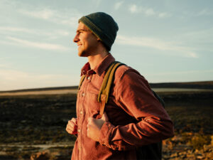 A man standing in a field at sunset